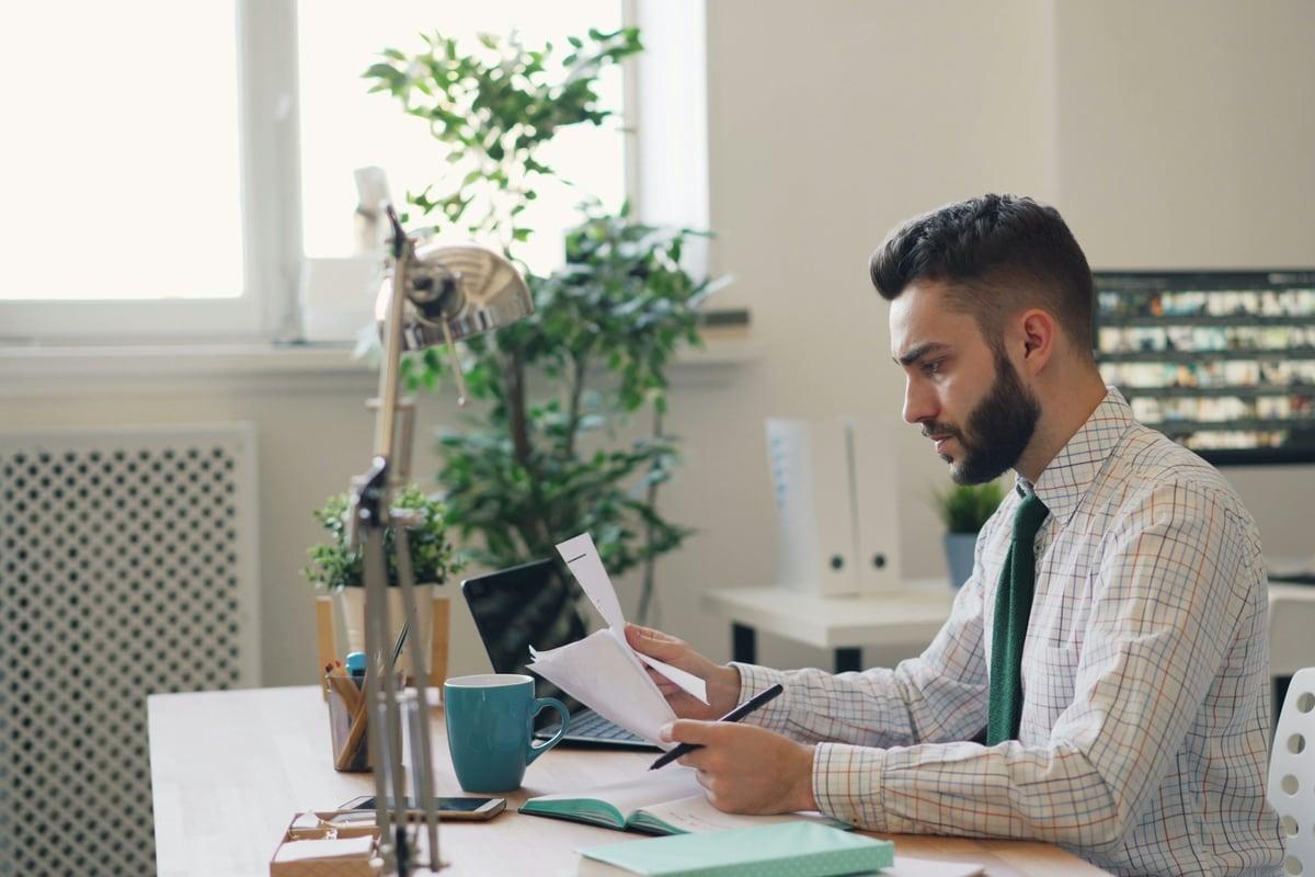 An accountant working through paperwork at an office desk