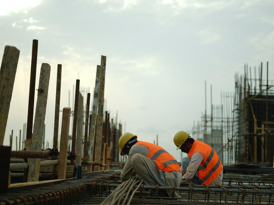 Construction workers fixing steel reinforcement on site
