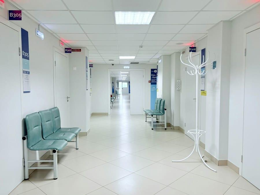 A clean hospital corridor with a seated waiting area