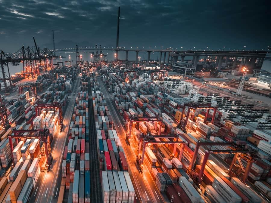 Shipping containers and cranes at a port at dusk